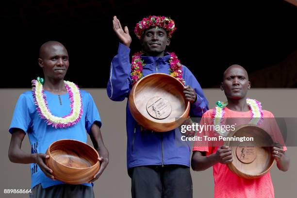 Lawrence Cherono of Kenya in second place, Dennis Kimetto of Kenya in first place and Titus Ekiru in third place pose during the awards ceremony...