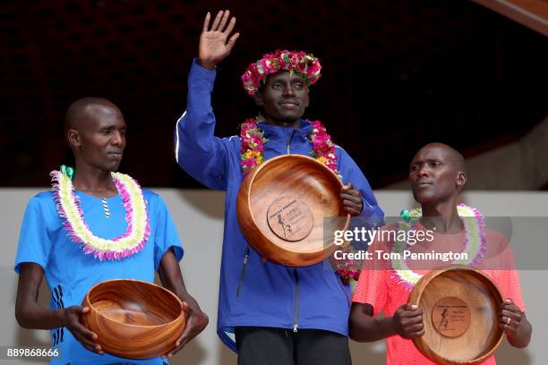 Lawrence Cherono of Kenya in second place, Dennis Kimetto of Kenya in first place and Titus Ekiru in third place pose during the awards ceremony...