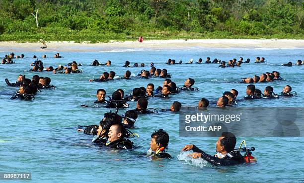 About 300 military and civilian Indonesian divers take to the waters of Tanjunglesung Beach in Indonesia's Banten province on July 11, 2009 to...