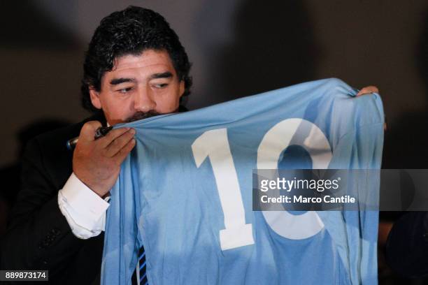 The famous football player Diego Armando Maradona, kisses his football jersey when he played at Napoli, during a press conference in Naples.