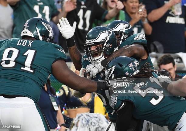 Linebacker Chris Long of the Philadelphia Eagles is mobbed by his teammates after stripping the ball from Jared Goff of the Los Angeles Rams at Los...