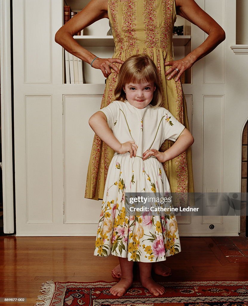 Girl (3-5) imitating mother's pose, hands on hips