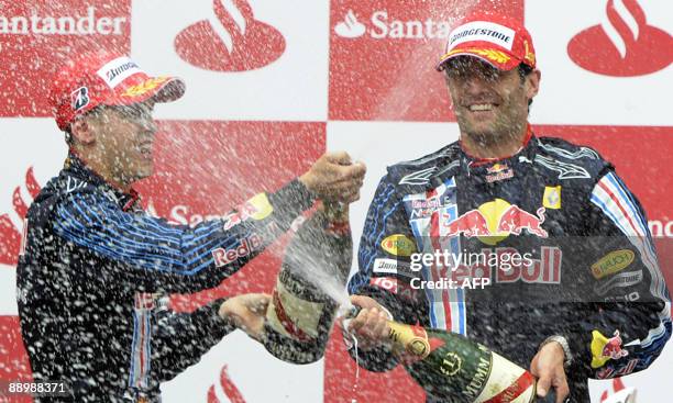 Red Bull's German driver Sebastian Vettel sprays champagne over Red Bull's Australian driver Mark Webber on the podium of the Nurburgring racetrack...