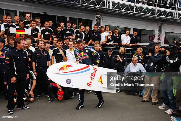 Mark Webber of Australia and Red Bull Racing celebrates with team mates in the paddock after winning the German Formula One Grand Prix at Nurburgring...
