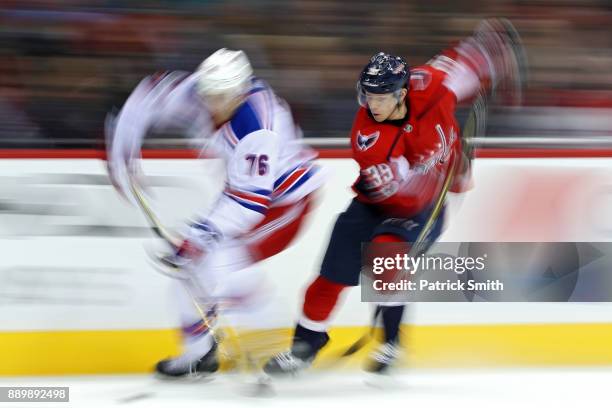 Brady Skjei of the New York Rangers and Alex Chiasson of the Washington Capitals battle for the puck during the second period at Capital One Arena on...