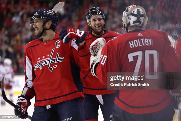 Alex Ovechkin of the Washington Capitals celebreates teammate Tom Wilson of the Washington Capitals goal against the New York Rangers during the...