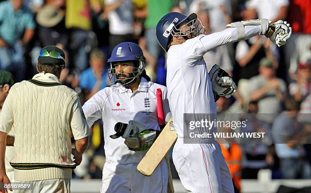 England batsman James Anderson celebrates towards the English fans while teammate Monty Panesar shakes hands with Australia Marcus North as England...