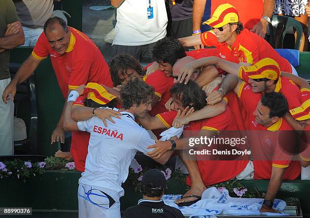 Juan Carlos Ferrero celebrates with teammates after beating Andreas Beck of Germany in the quarter-finals of the Davis Cup World Group at the Plaza...