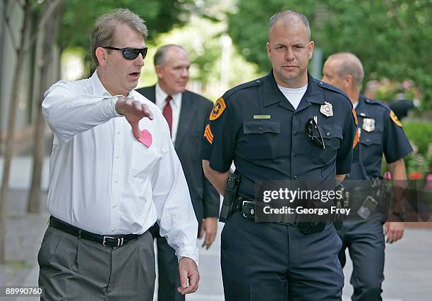 Protester Jeff Wroble is escorted off the Main Street Plaza by a Salt Lake City policeman as a Mormon Church security guard follows in the background...