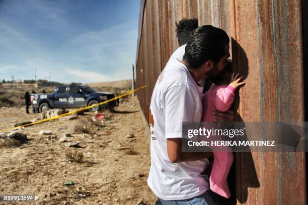 Man holds a baby next the border wall between Mexico and United States, during the "Keep our dream alive" event, in Ciudad Juarez, Chihuahua state,...