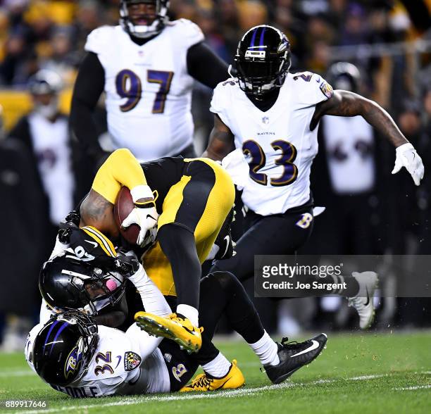 Le'Veon Bell of the Pittsburgh Steelers is wrapped up for a tackle by Eric Weddle of the Baltimore Ravens in the second quarter during the game at...
