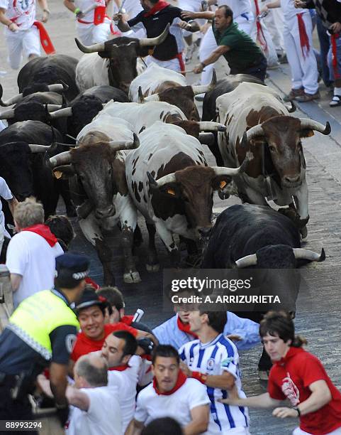 Participants run with Fuente Ymbro fighting bulls on the seventh day of the San Fermin Festival bull run, on July 13 in Pamplona, northern Spain. The...