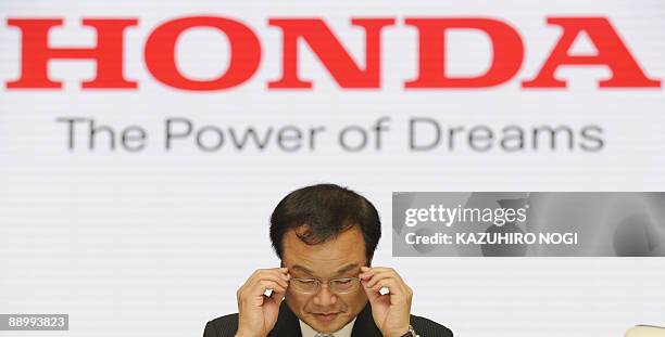 Chief executive officer of Japan's second-largest automaker Honda Motor Co., Takanobu Ito, adjusts his glasses as he takes part in a joint interview...