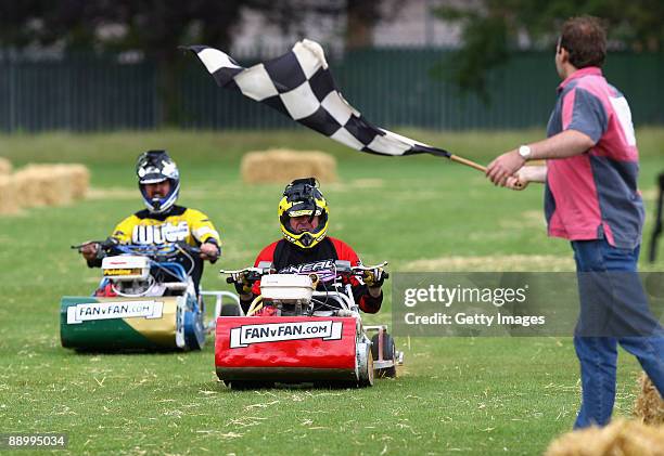 Ashes legend Phil 'Tuffers' Tufnell of England crosses the finish line to win over Jason 'Dizzy' Gillespie of Australia during the Betfair Lawnmower...