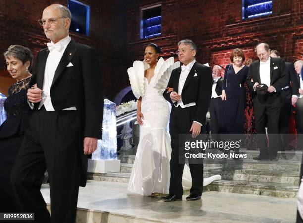 Japan-born British novelist Kazuo Ishiguro enters a Stockholm City Hall room to attend a banquet sponsored by Sweden's King Carl XVI Gustaf for the...