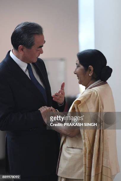 China's Foreign Minister Wang Yi is received by Indian External Affairs Minister Sushma Swaraj during his arrival for a meeting in New Delhi on...