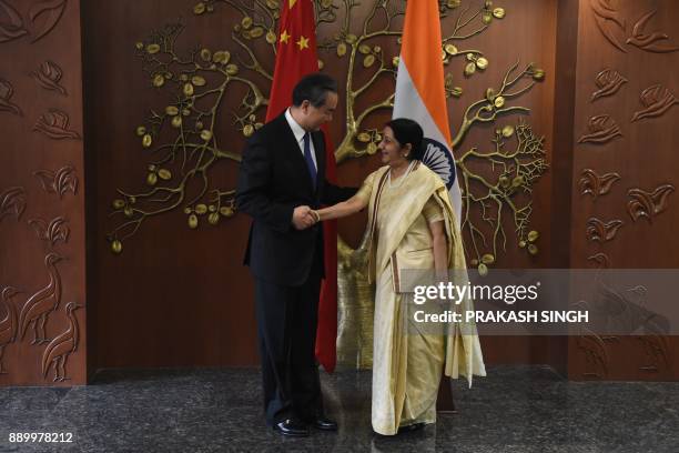 China's Foreign Minister Wang Yi shakes hands with Indian External Affairs Minister Sushma Swaraj prior to a meeting in New Delhi on December 11,...