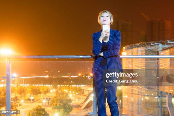 businesswoman using cellphone at footbridge of airport/station - center of gravity 2017 stock pictures, royalty-free photos & images