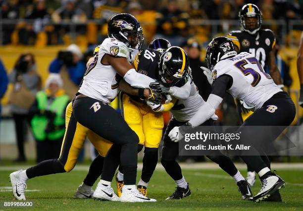 Le'Veon Bell of the Pittsburgh Steelers is gang tackled by the Baltimore Ravens in the second half during the game at Heinz Field on December 10,...