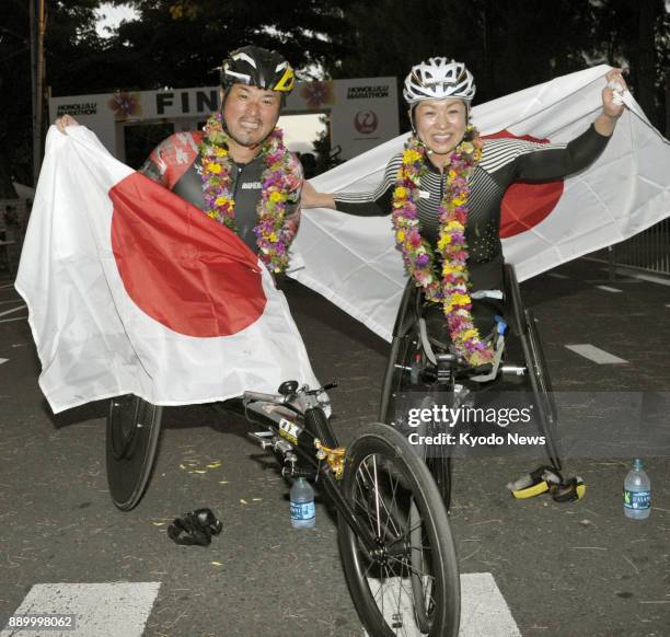 Masazumi Soejima and Wakako Tsuchida, both of Japan, pose with flag after winning the men's and women's wheelchair divisions of the Honolulu Marathon...