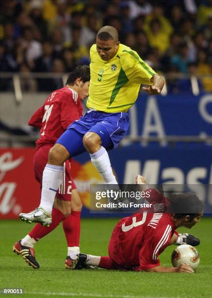 Ronaldo of Brazil is tackled by Bulent Korkmaz of Turkey during the FIFA World Cup Finals 2002 Semi-Final match played at the Saitama Stadium, in...