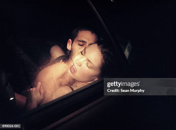 couple embracing passionately in car - car passion stock pictures, royalty-free photos & images