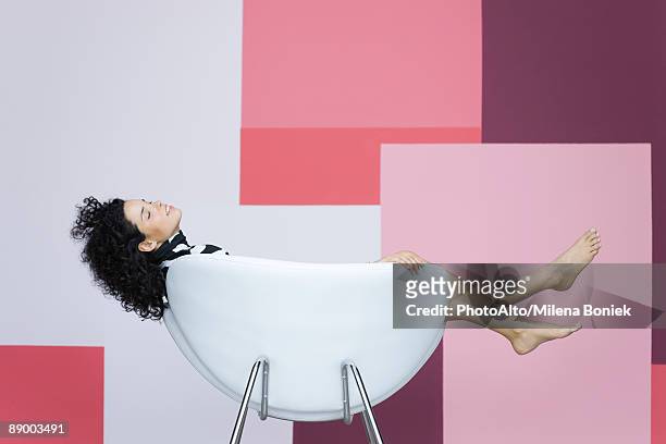 young woman reclining in armchair - lazy day fotografías e imágenes de stock