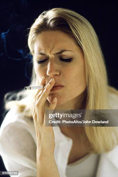 woman smoking, eyes closed - knitting brow stock pictures, royalty-free photos & images