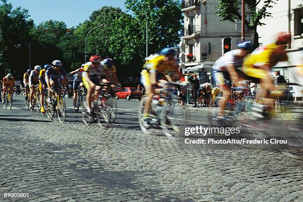 cyclists racing on cobblestone street - evento de ciclismo imagens e fotografias de stock