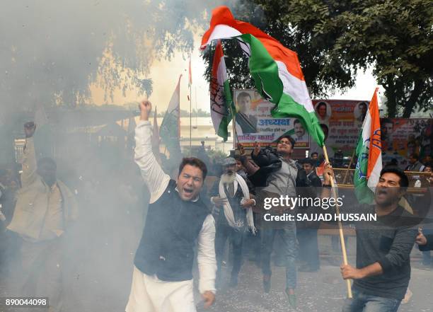 Indian supporters of the Congress Party shout slogans after the party named Rahul Gandhi president, outside Congress headquarters in New Delhi on...