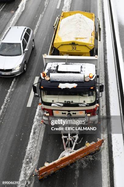 Snow truck clears and spreads salt on the E40 highway in Sterrebeek, as cold temperatures sweep across Belgium on December 11, 2017. / AFP PHOTO /...