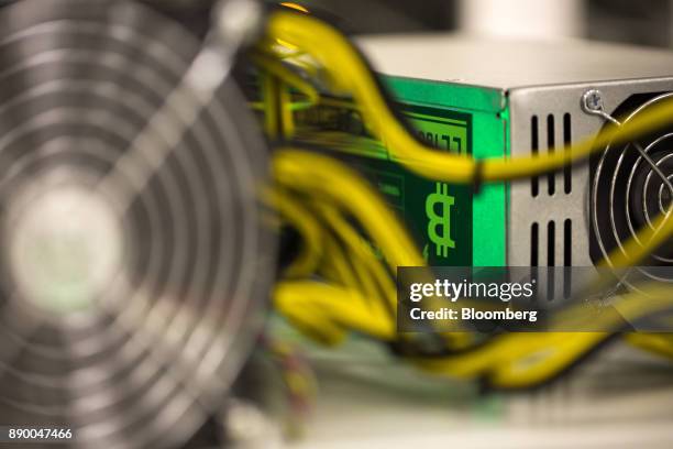 Bitcoin logo sits on a LL 1800W power unit supplying cryptocurrency mining machines at the SberBit mining 'hotel' in Moscow, Russia, on Saturday,...