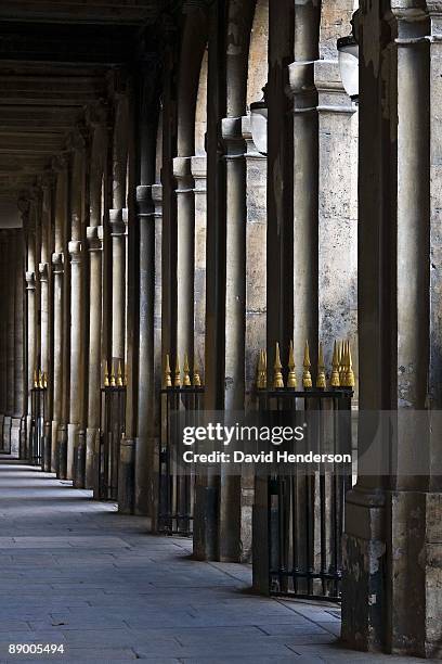 hallway with arches and ornamental fences, jardin du palais royal, paris, france - palais royal stockfoto's en -beelden