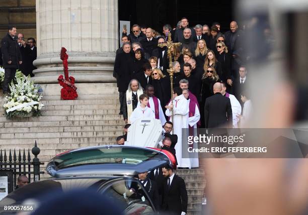 Pallbearers carry the coffin in the hearse outside the La Madeleine Church at the end of the funeral ceremony in tribute to late French singer Johnny...