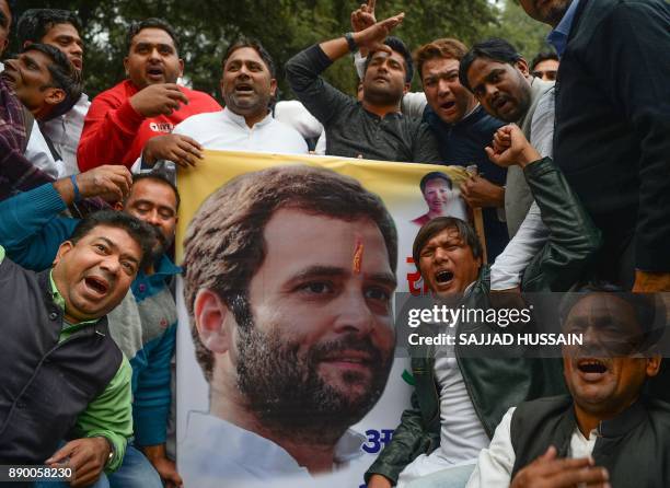 Indian supporters of the Congress Party shout slogans after the party named Rahul Gandhi president, outside Congress headquarters in New Delhi on...