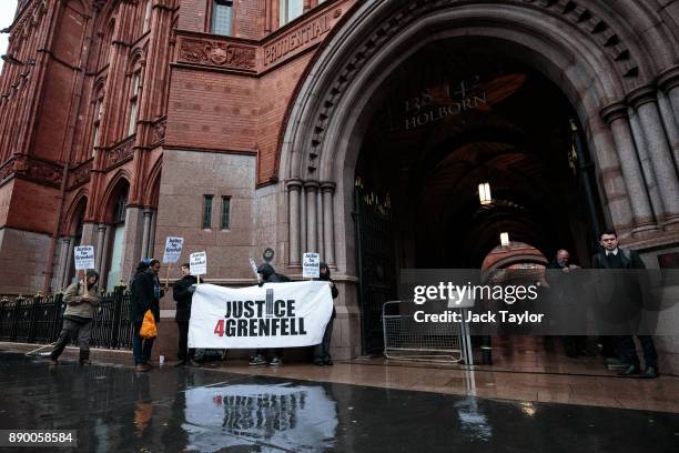 Protesters stand with a banner and placards outside Holborn Bars before a two-day hearing as part of the inquiry into the Grenfell Tower fire on...