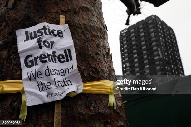 Justice for Grenfell' sign hangs on a tree near Grenfell Tower on December 11, 2017 in London, England. An inquiry into the Grenfell Tower fire was...