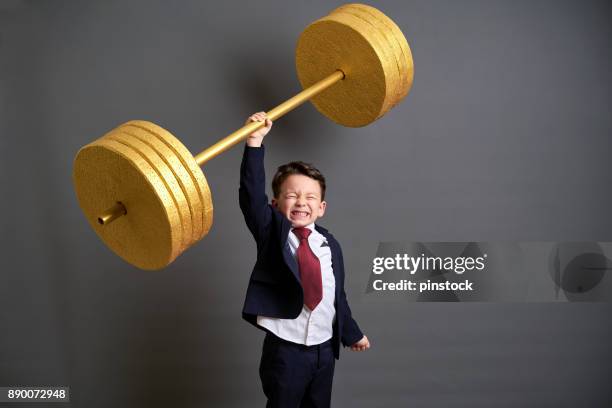 cute business boy lifting gold barbell - golden boy stock pictures, royalty-free photos & images