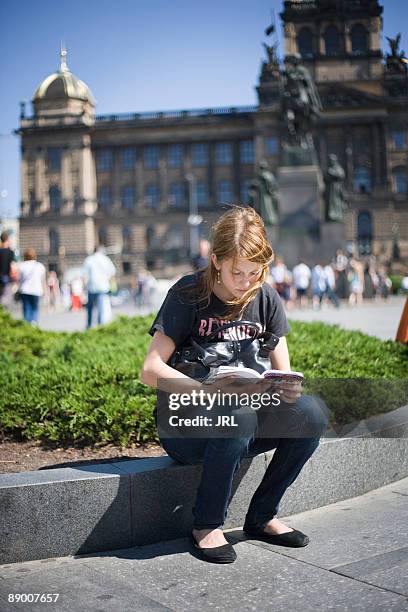 woman reading in wenceslas square, prague, czech republic - common aims stock-fotos und bilder