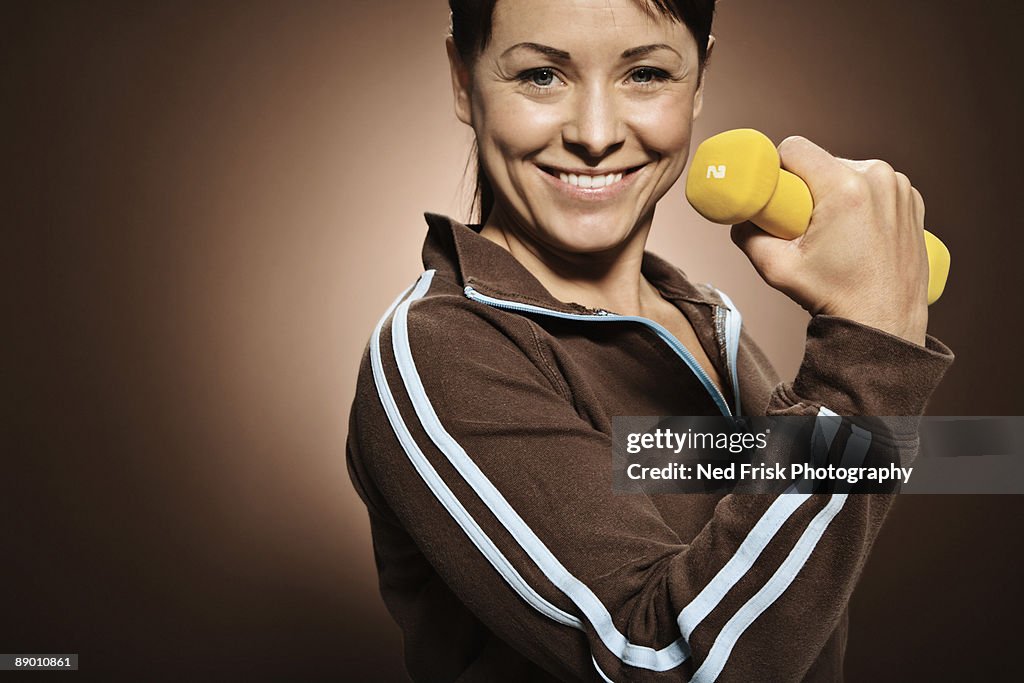 Smiling woman with dumbbell