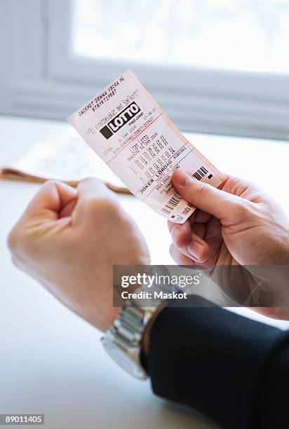 man with lottery ticket - artículos de lotería fotografías e imágenes de stock