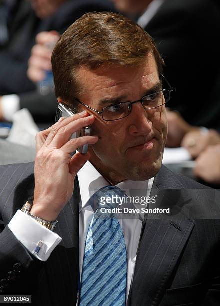 Washington Capitals General Manager George McPhee listens on to his phone while seated at the Capitals draft table during the second day of the 2009...