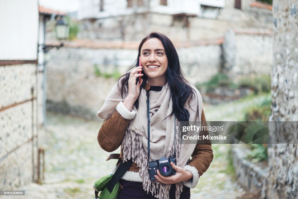 Female tourist walking and talking on the phone