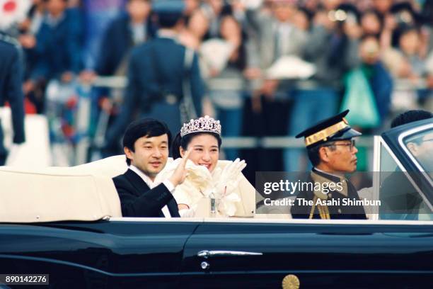 Crown Prince Naruhito and Crown Princess Masako wave to well-wishers during the royal wedding parade on June 9, 1993 in Tokyo, Japan.