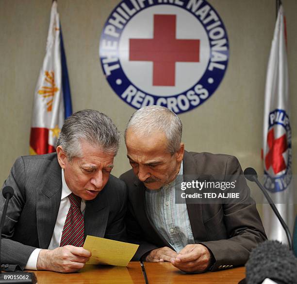 Freed Italian hostage Eugenio Vagni confers with Italian ambassador Rubens Fedele during a press conference at the Philippine Red Cross headquarters...