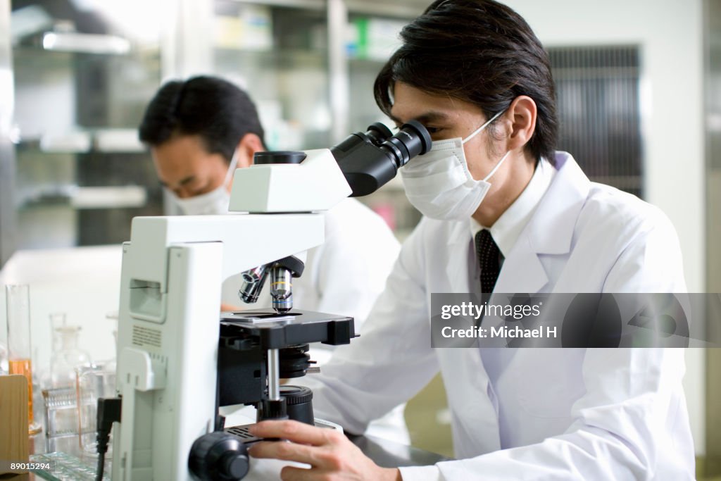 Researcher who looks through microscope