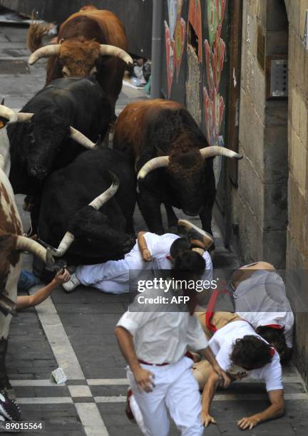 Runners fall in front of Nuñez del Cuvillo fighting bulls on the last San Fermin Festival bull run, on July 14 in Pamplona, northern Spain. The...