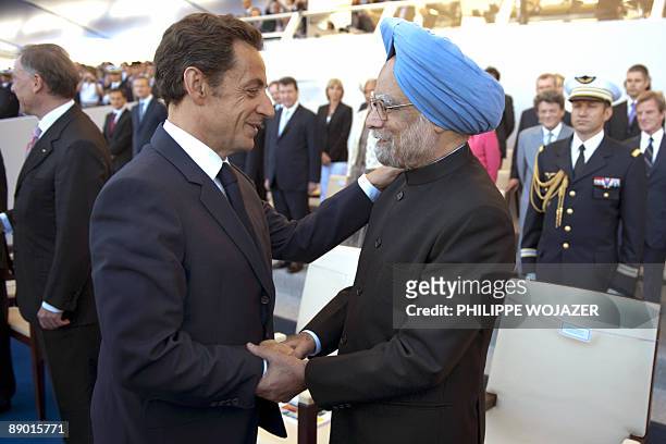 France's President Nicolas Sarkozy shakes hands with Indian Prime Minister Manmohan Singh upon arrival at the Place de la Concorde in Paris to attend...