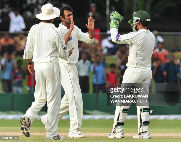 Pakistan cricketer Shoaib Malik celebrates with teammates the dismissal of Sri Lankan cricket captain Kumar Sangakkara during the third day of the...