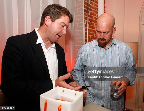 Palm representative Tim Petitt, left, demonstrates the palm Pre to Boston Red Sox All-Star first-baseman Kevin Youklis at the Palm Gift Lounge at the...